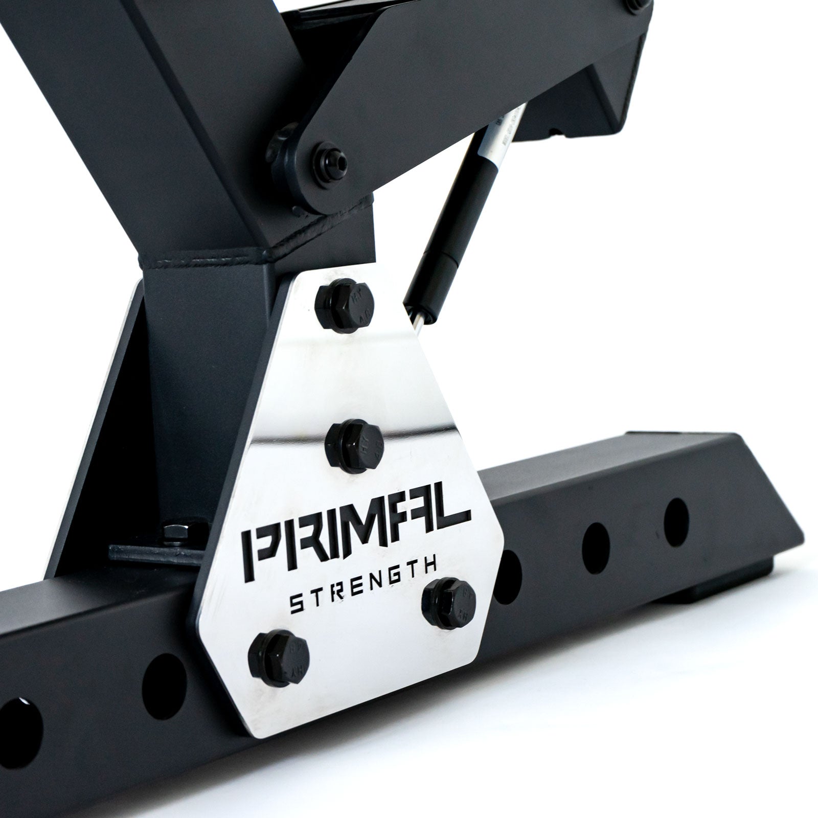 a metal plate with a lasered primal strength logo on a preacher curl bench