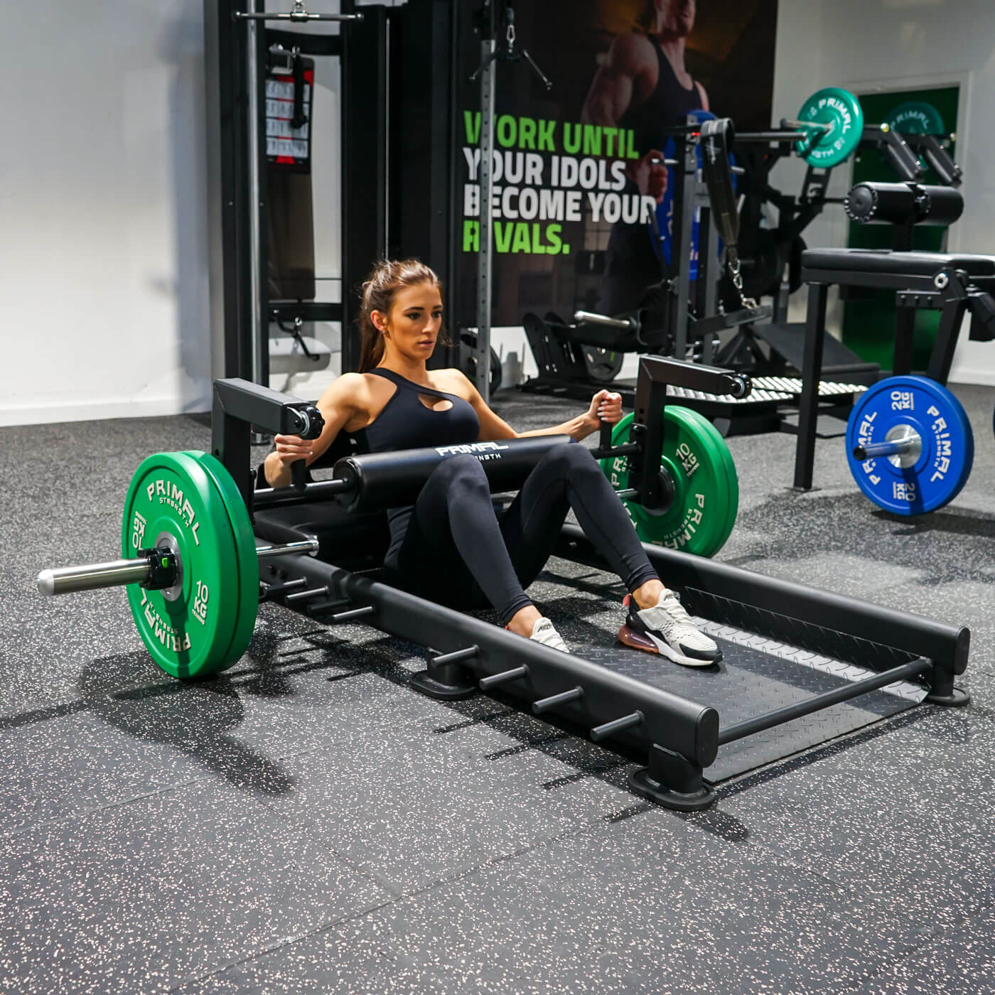 a woman performing hip thrusts with a hip thrust barbell and floor hip thrust bench