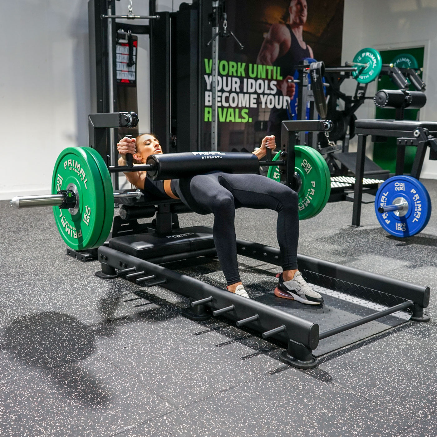 a woman performing hip thrusts with a hip thrust barbell and floor hip thrust bench