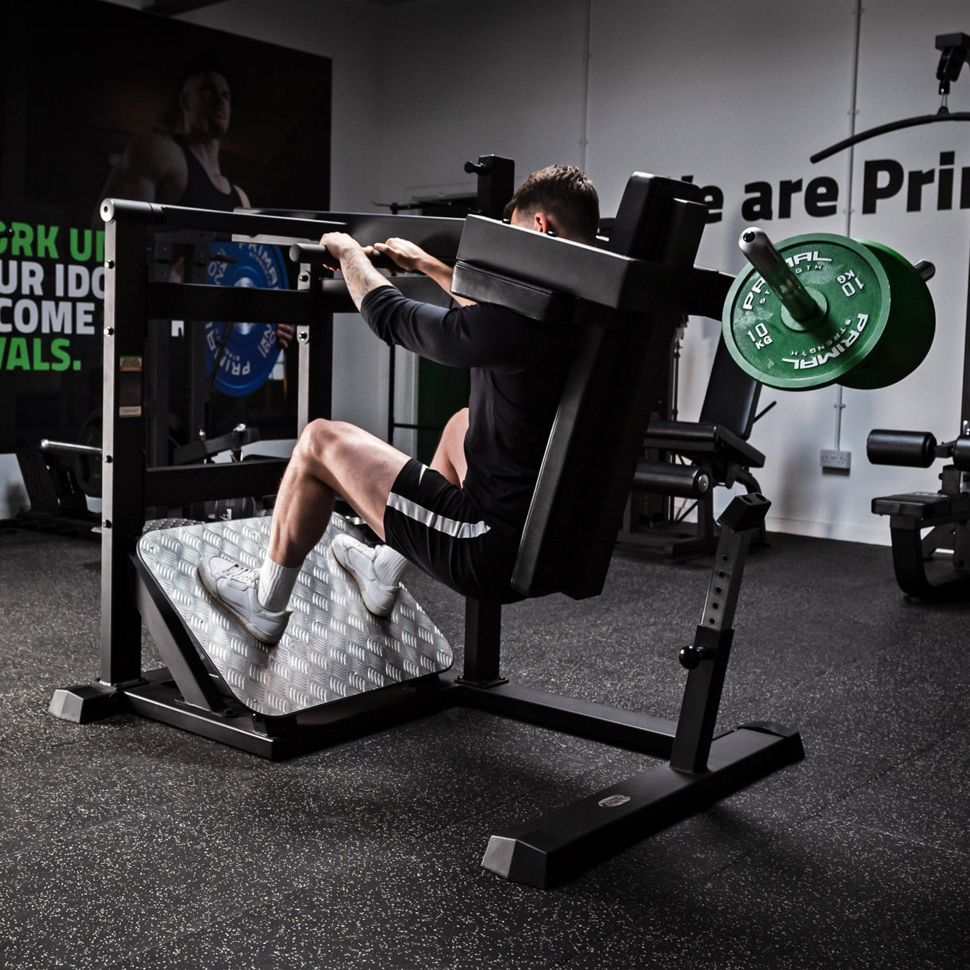 a man exercising on the pendulum squat gym machine