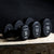 three single primal strength black urethane dumbbells on a wooden box