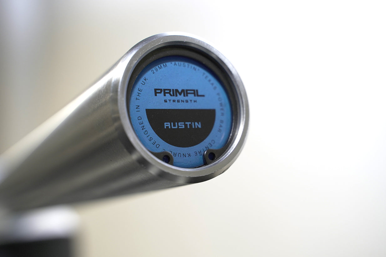 the blue sleeve end cap of a silver olympic barbell