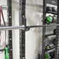a silver olympic barbell on a rack with functional exercise equipment in the background