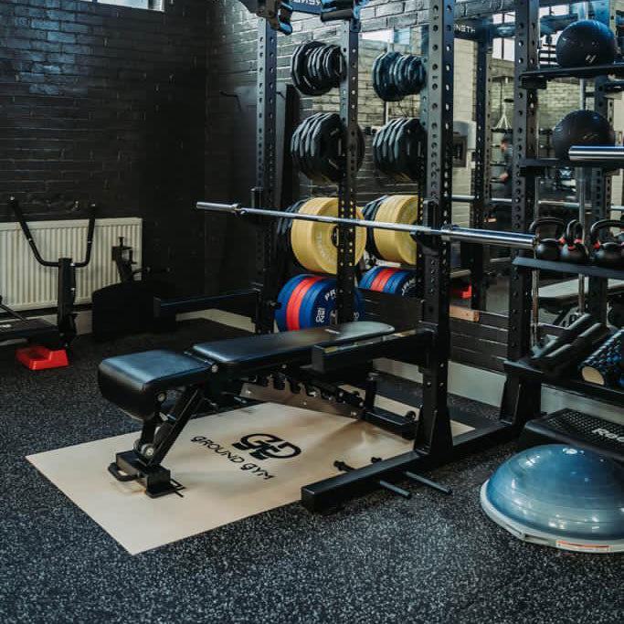 a custom olympic platform under a gym rack