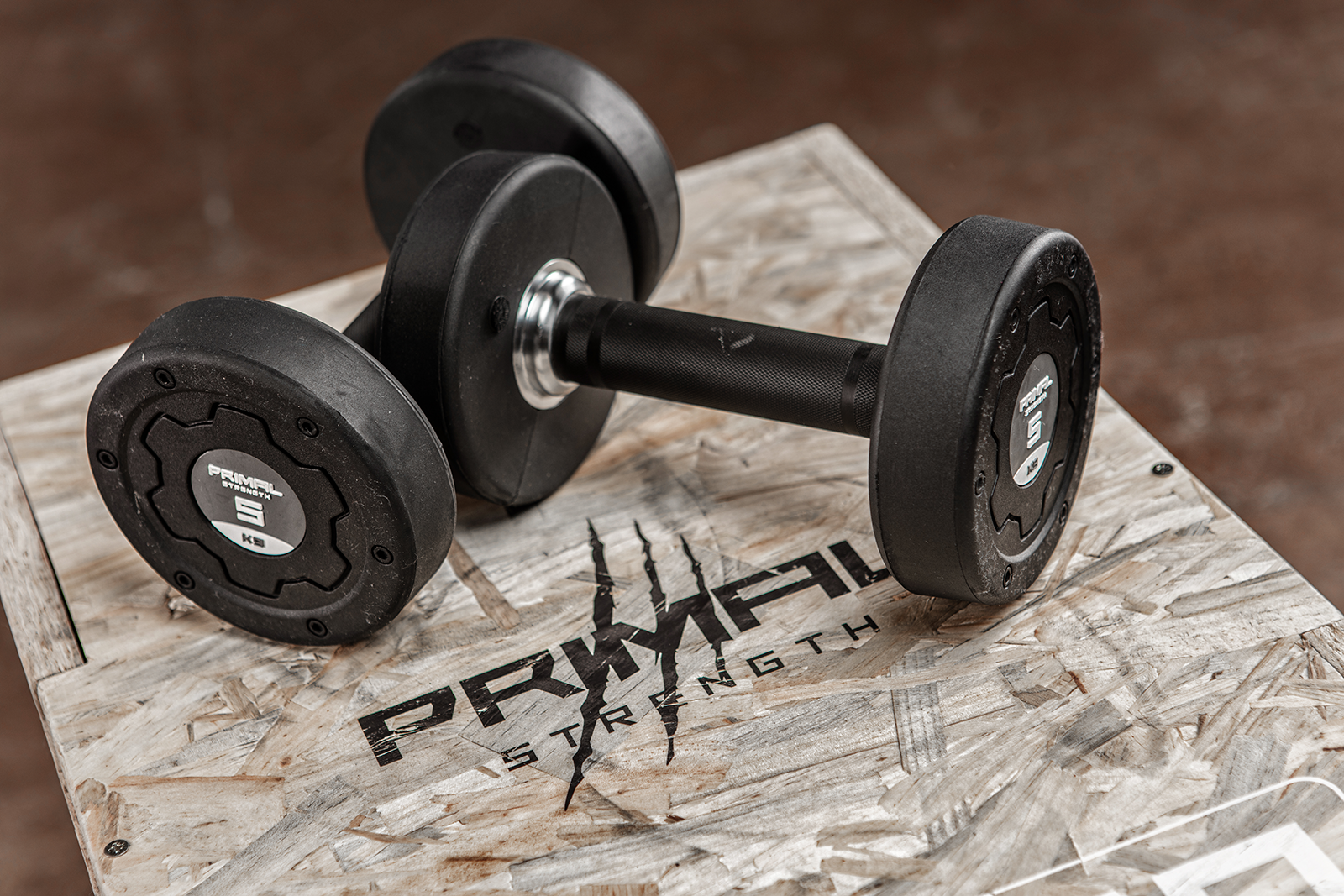 a pair of 5kg rubber dumbbells on a wooden plyo box